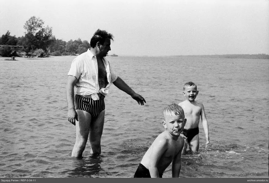 Mann und Kinder im Wasser am Ufer