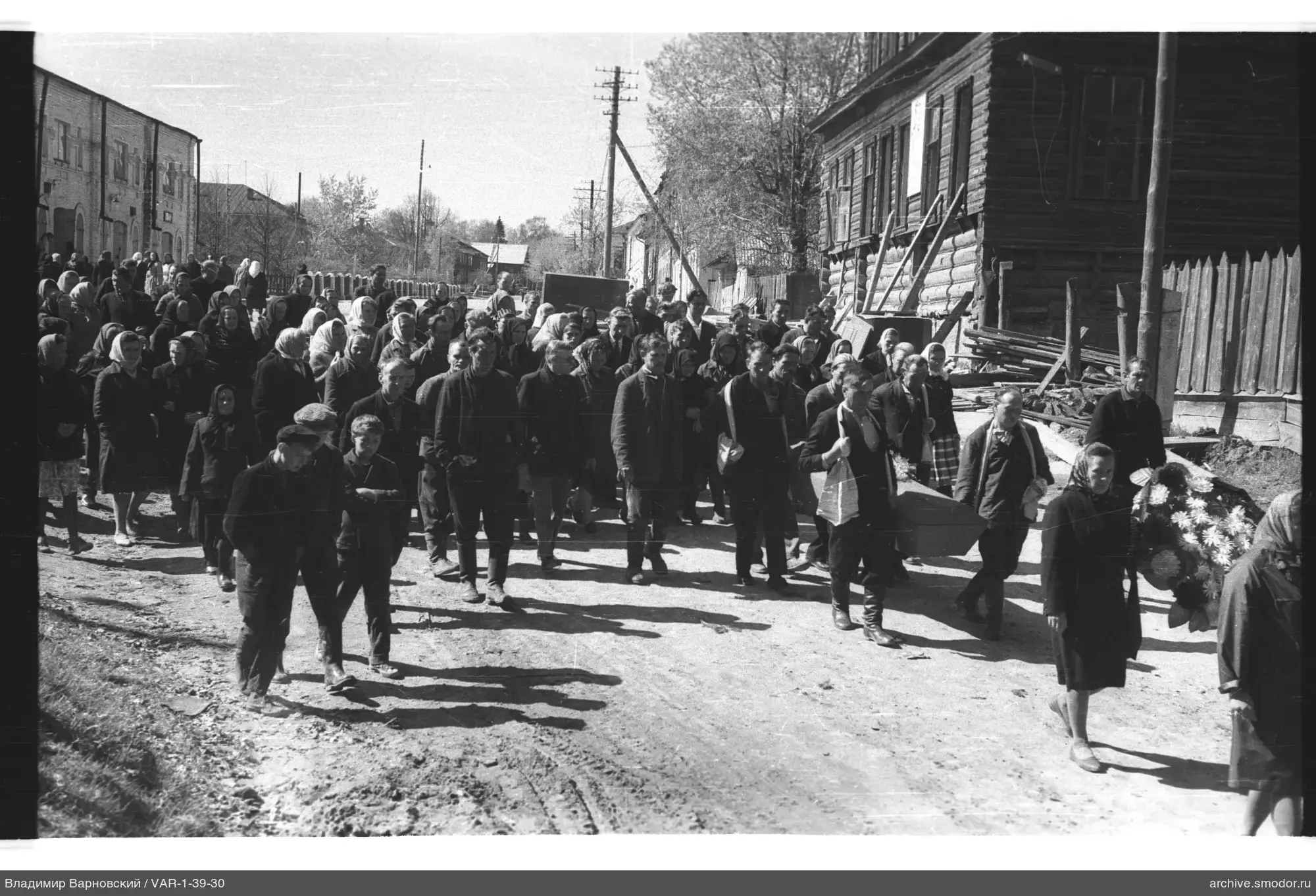 Gruppe von Menschen auf Straße mit Sarg und Kranz