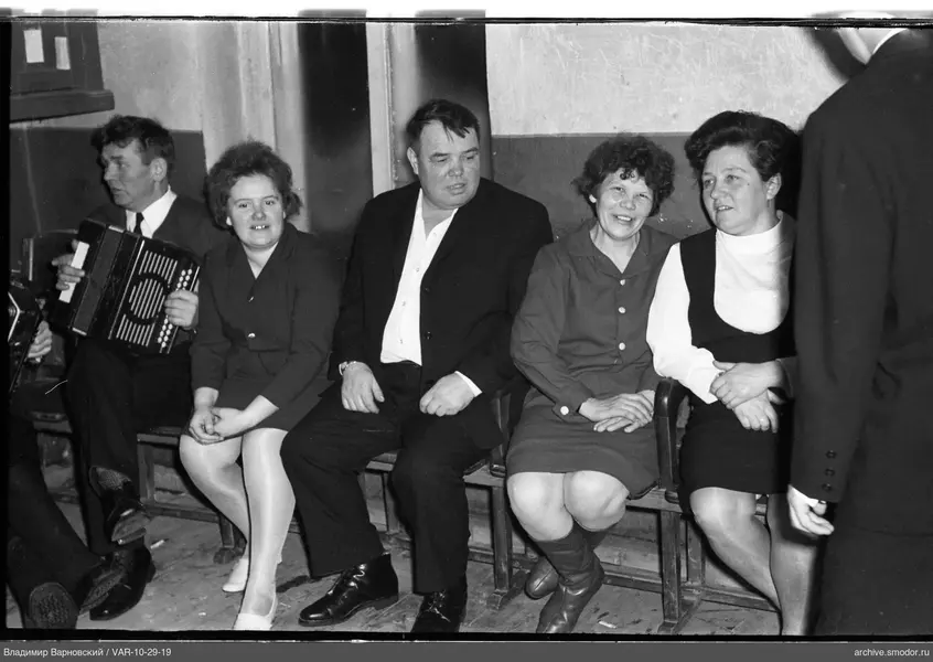 Group of people on a bench by the wall
