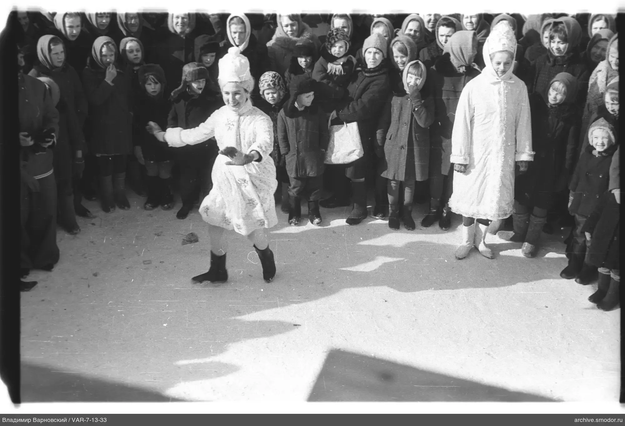 Две девочки в светлых пальто и шапках