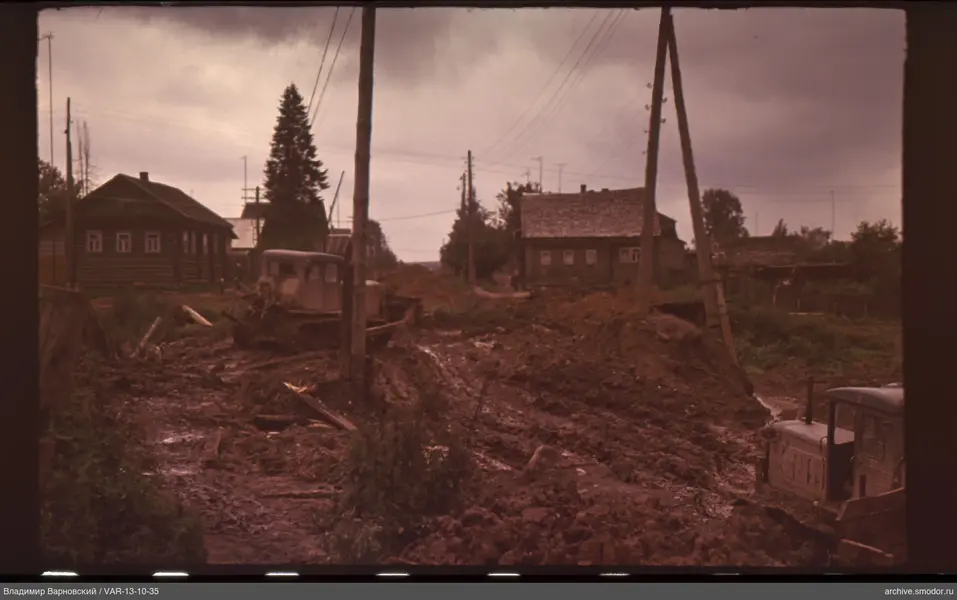 Road with bulldozers and wooden houses