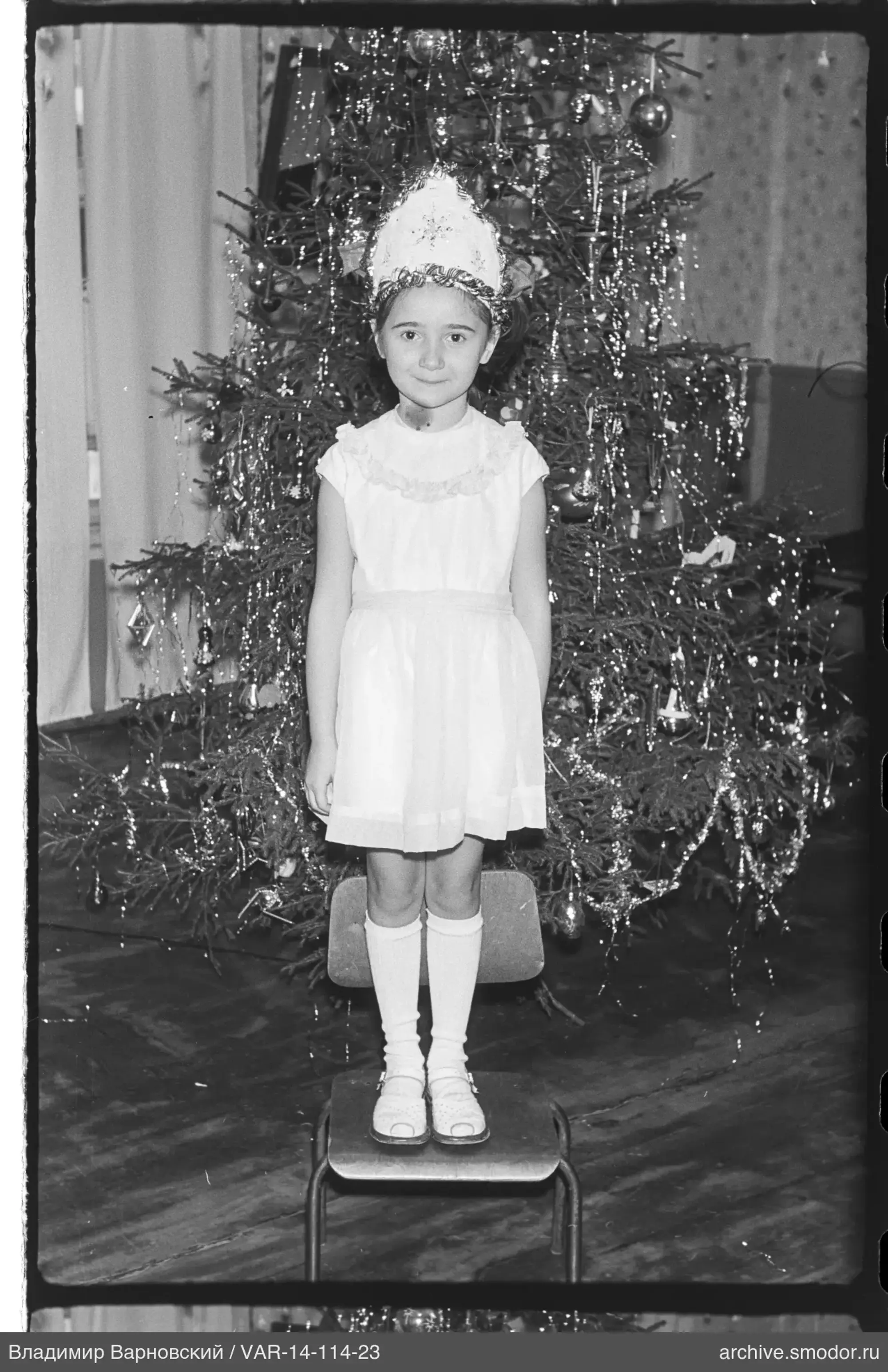 Mädchen vor geschmücktem Weihnachtsbaum