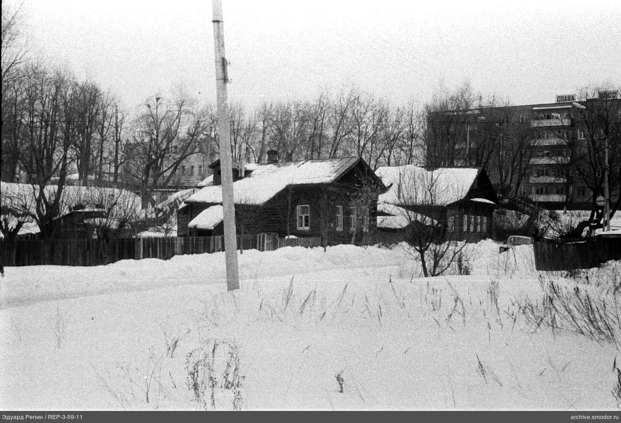 Schneebedecktes Feld und Holzhaus