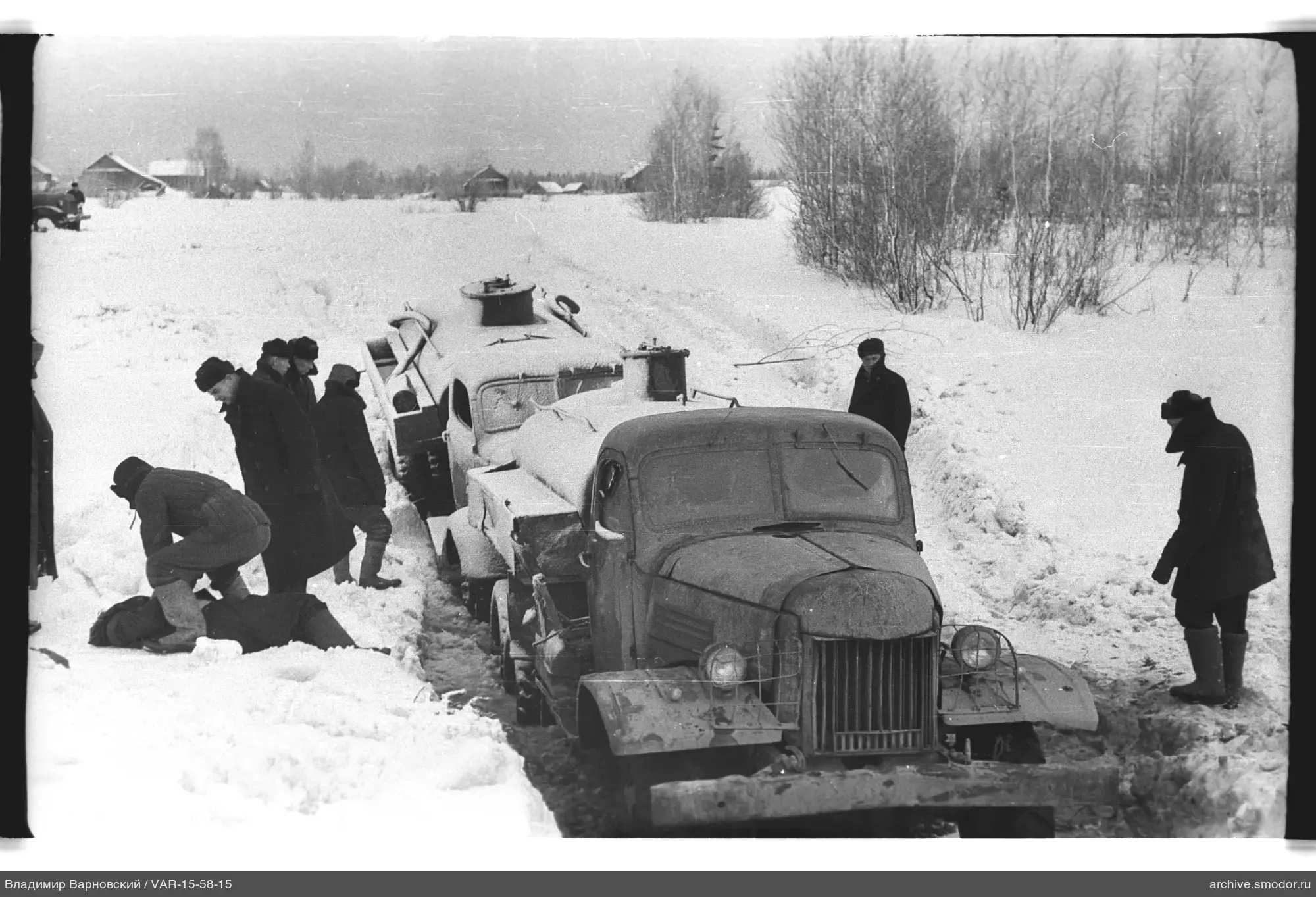 Männer bei festgefahrenen Tanklastwagen im Schnee