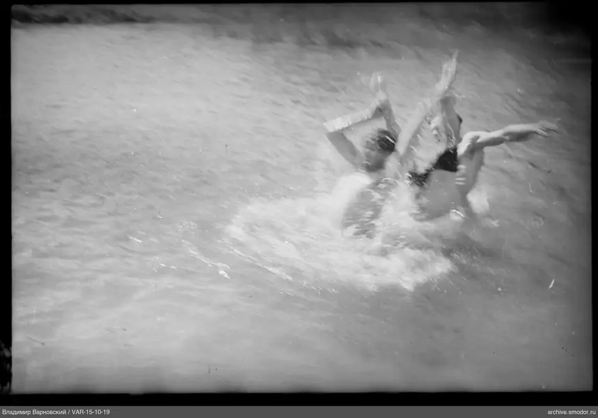 Zwei Personen im Wasser mit erhobenen Händen