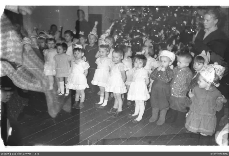 Gruppe von Kindern in festlichen Kostümen und Weihnachtsbaum