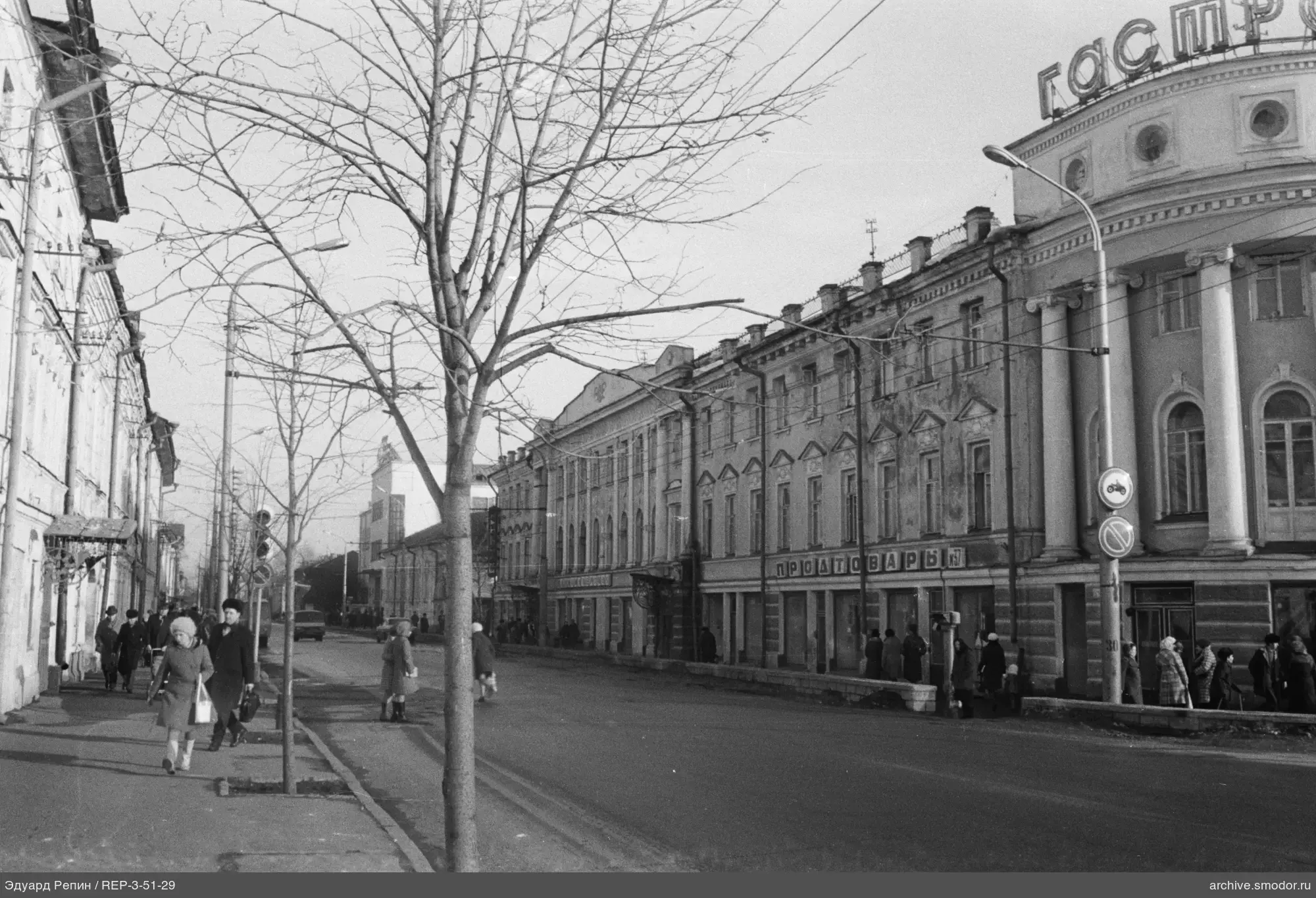 Straße mit Fußgängern und einem Säulengebäude