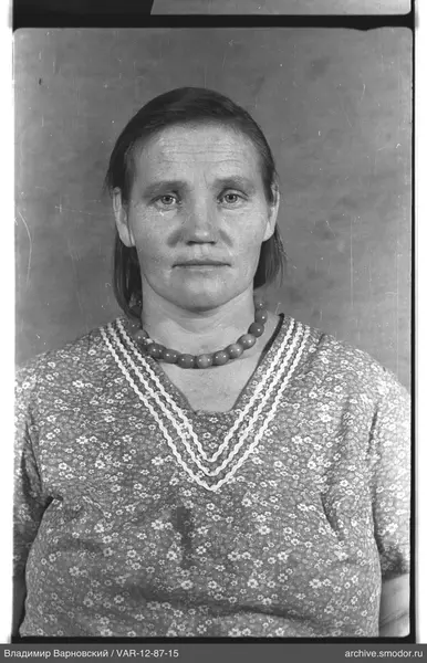 Портрет женщины в платье с брошью и бусами