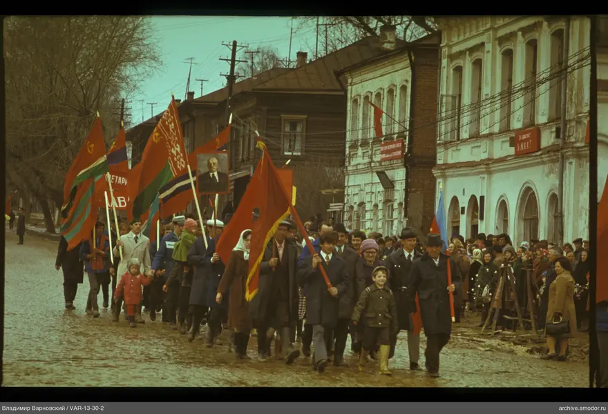 Gruppe mit Fahnen und Porträt auf Straße
