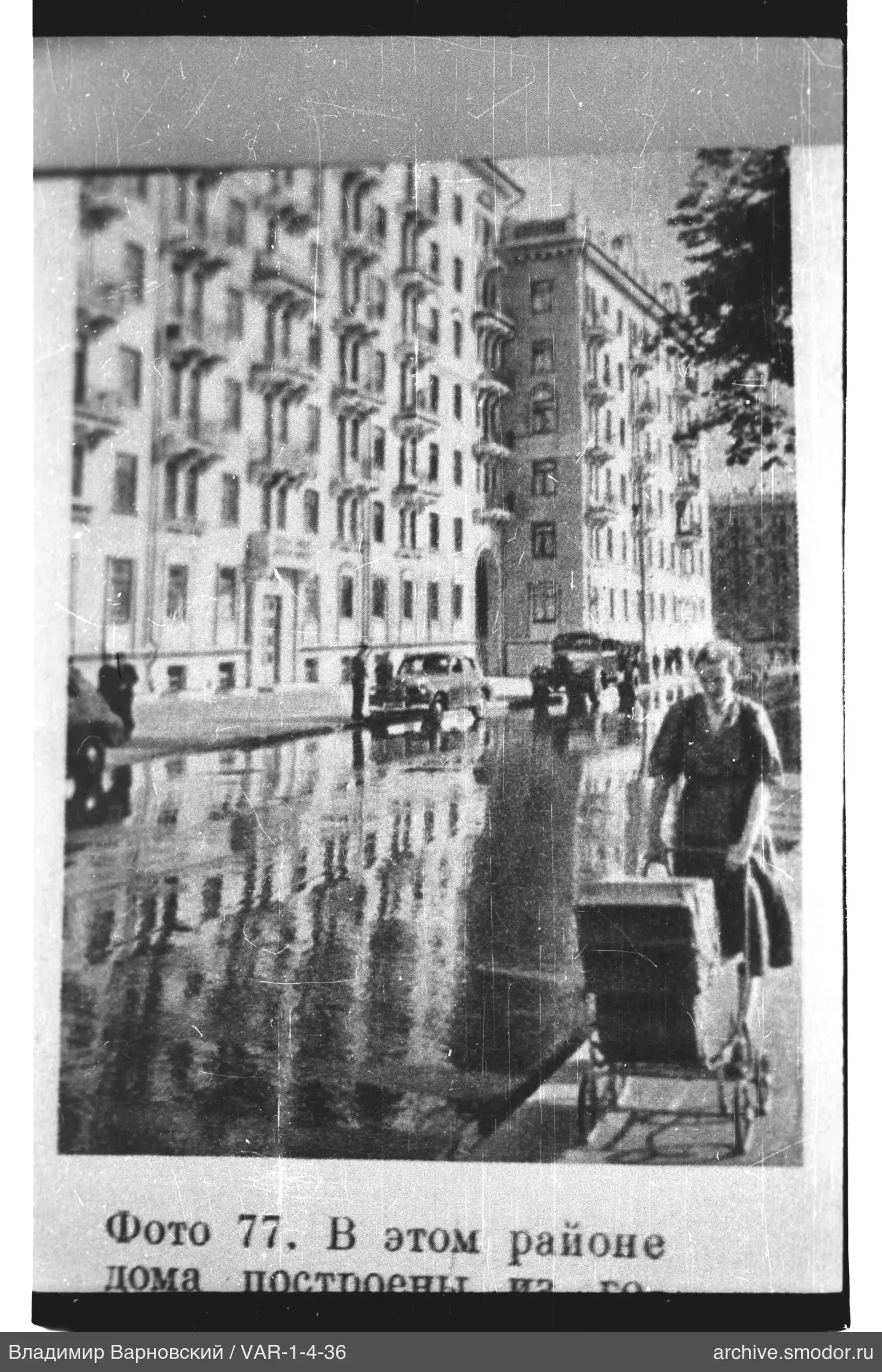 Straße mit Wohnhaus und Frau mit Kinderwagen