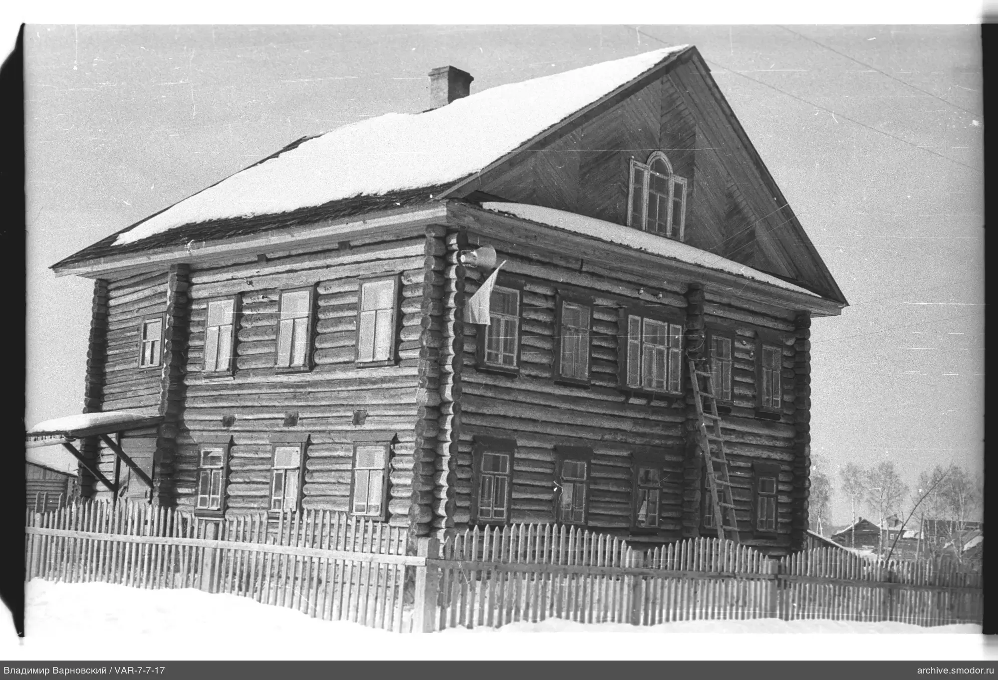 Zweistöckiges Holzhaus mit Leiter und Flagge