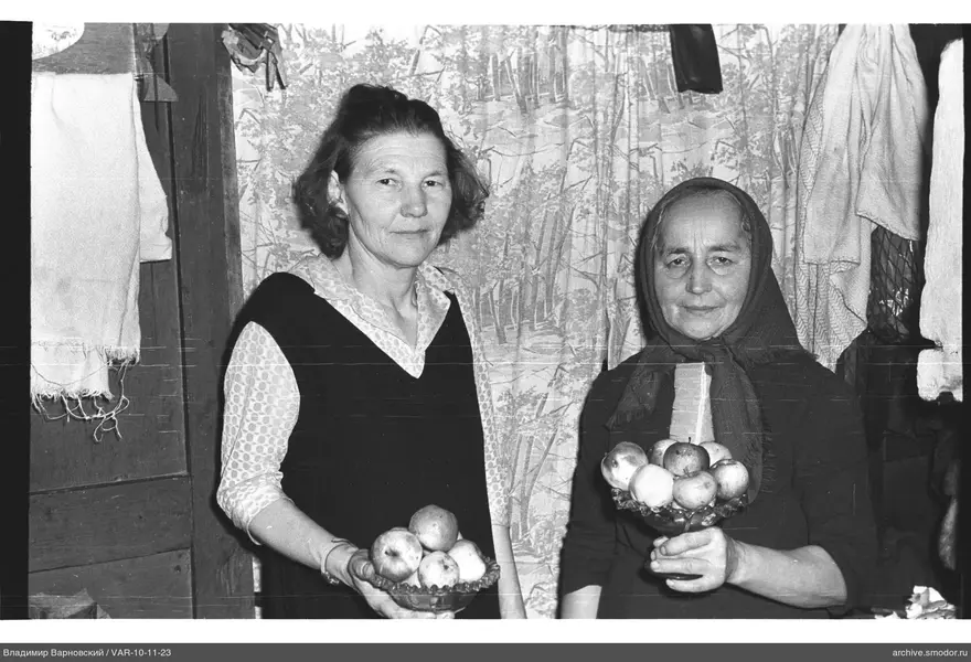 Two women holding plates with apples