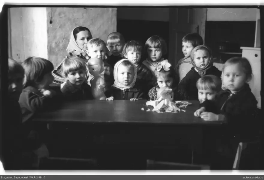 Group portrait of children and woman at table