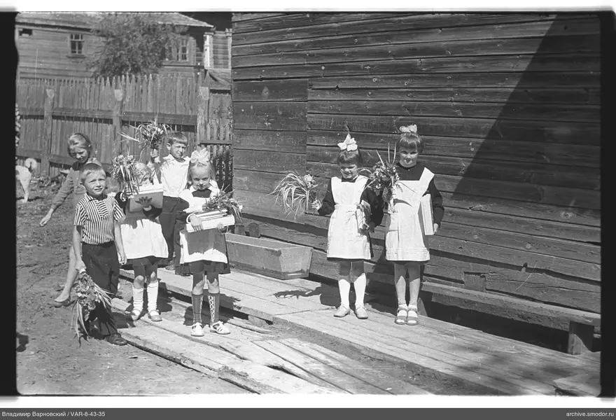 Gruppe von Kindern vor einem Holzgebäude