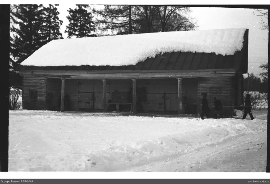 Holzgebäude mit Veranda und Personen im Schnee