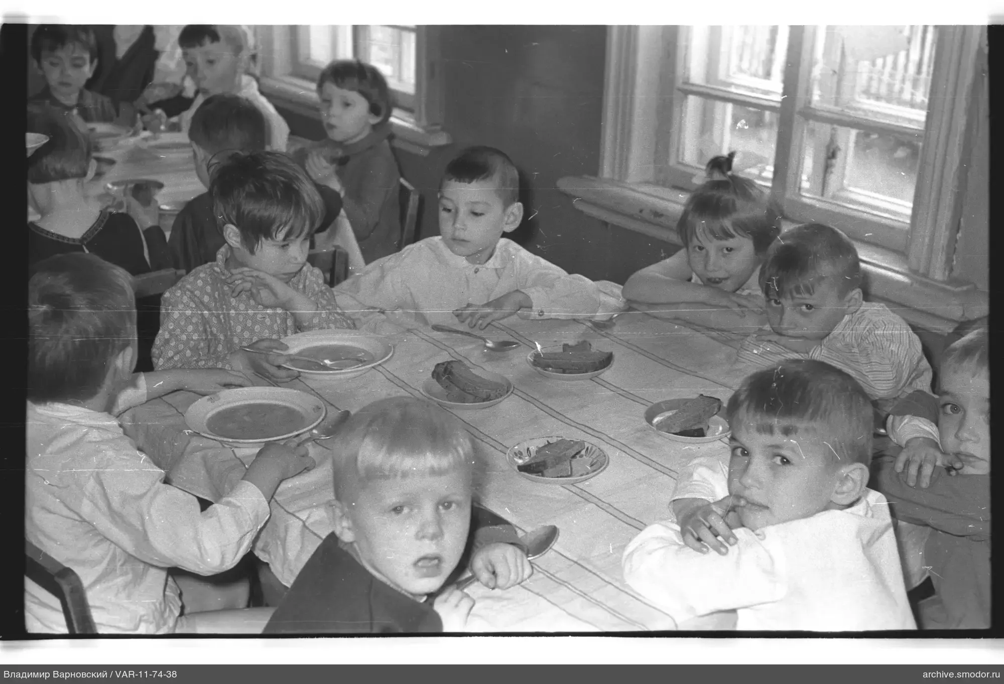 Kinder am Tisch mit Suppe und Brot