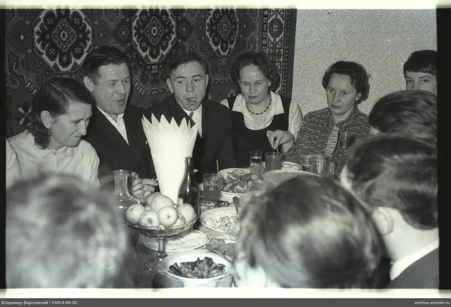 Gruppe am Tisch mit Geschirr und Früchten