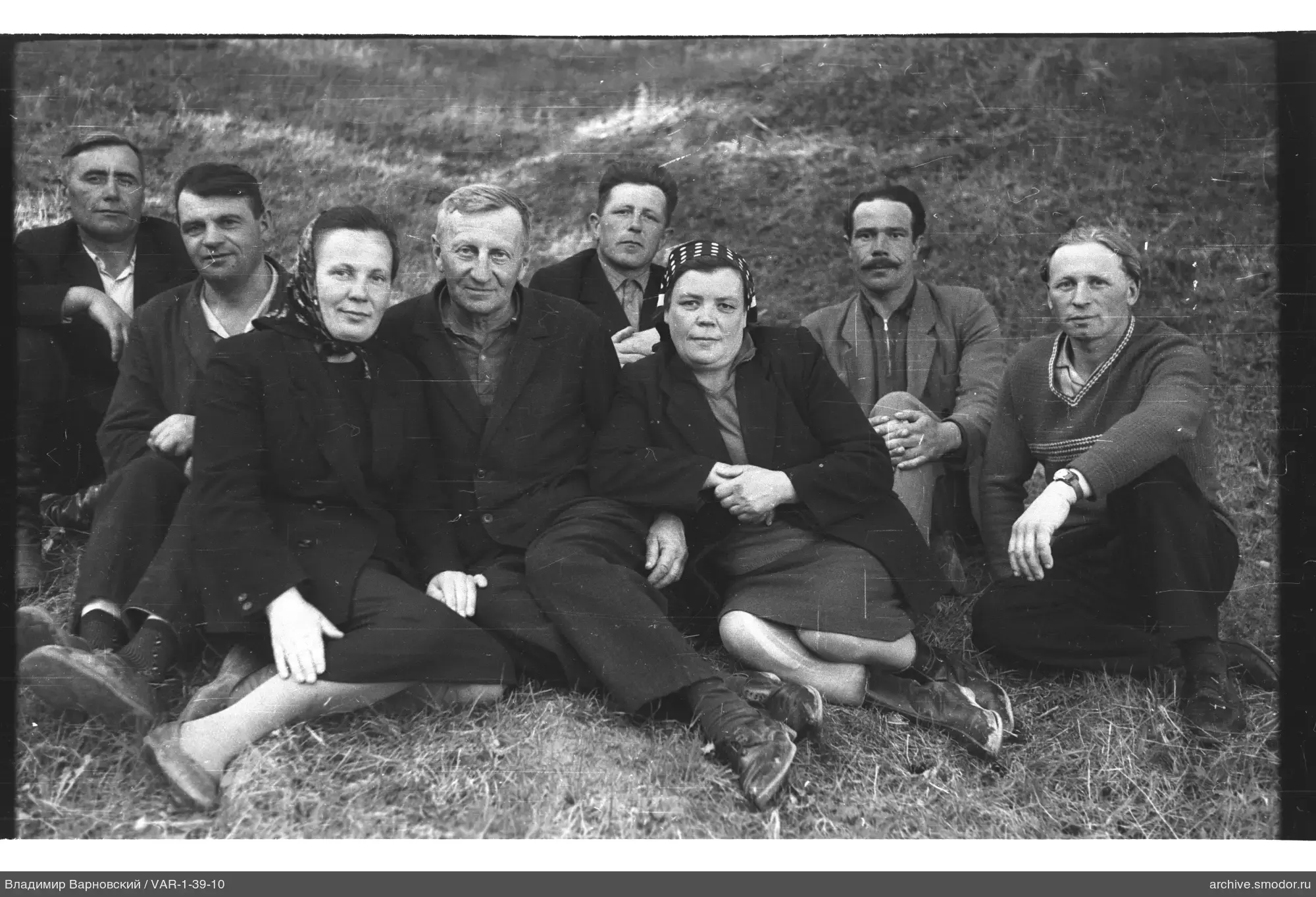 Gruppe von Menschen auf Gras am Hang