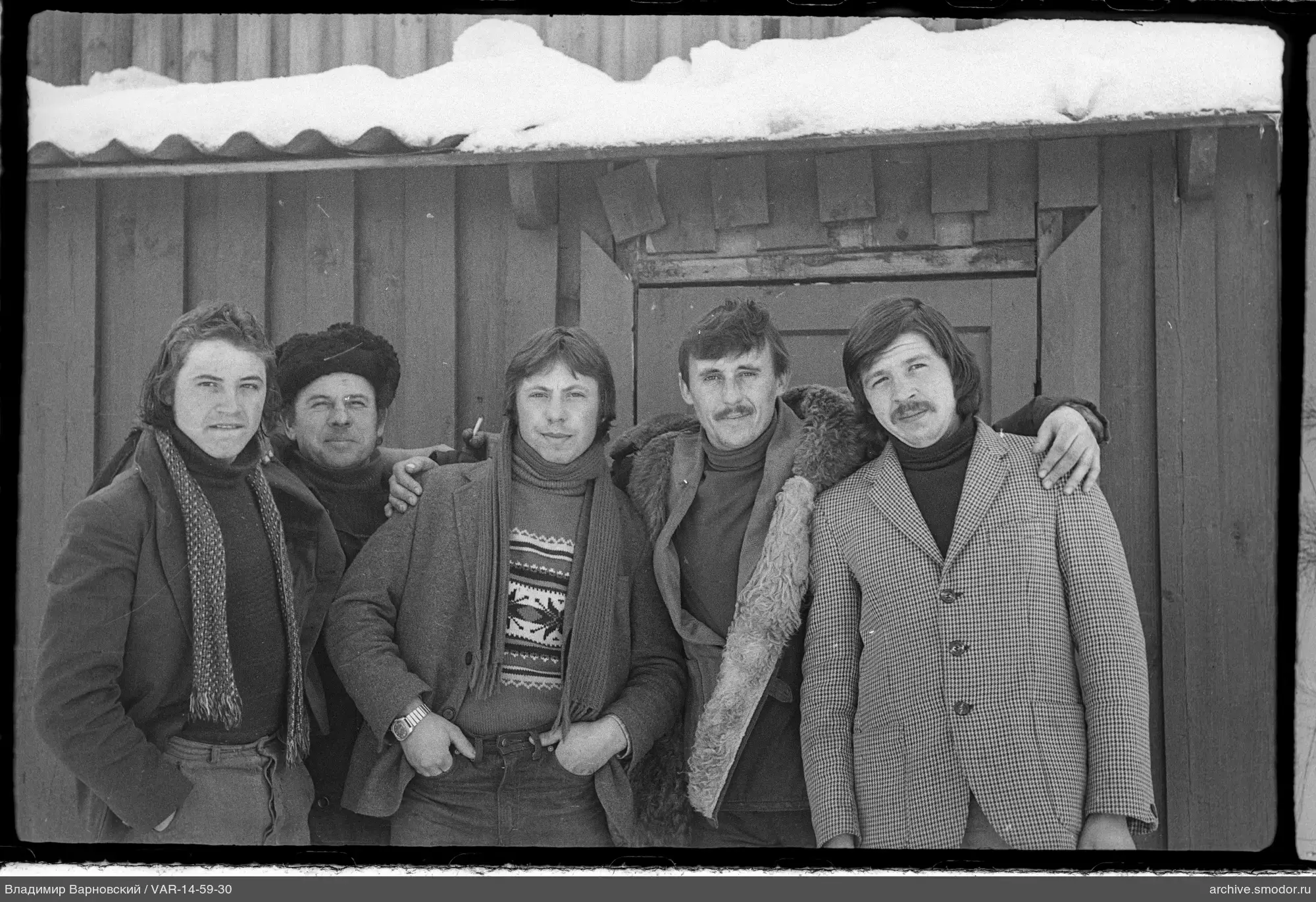 Gruppe von Männern vor Holzwand