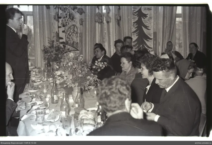 Group sitting at a table with dishes and flowers