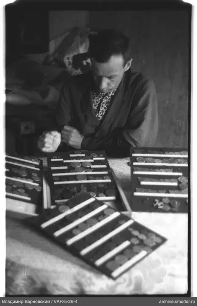 Man with coins and tags at table