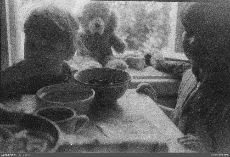 Zwei Kinder am Tisch neben dem Fenster