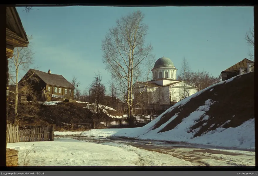 Landscape with wooden house and white building