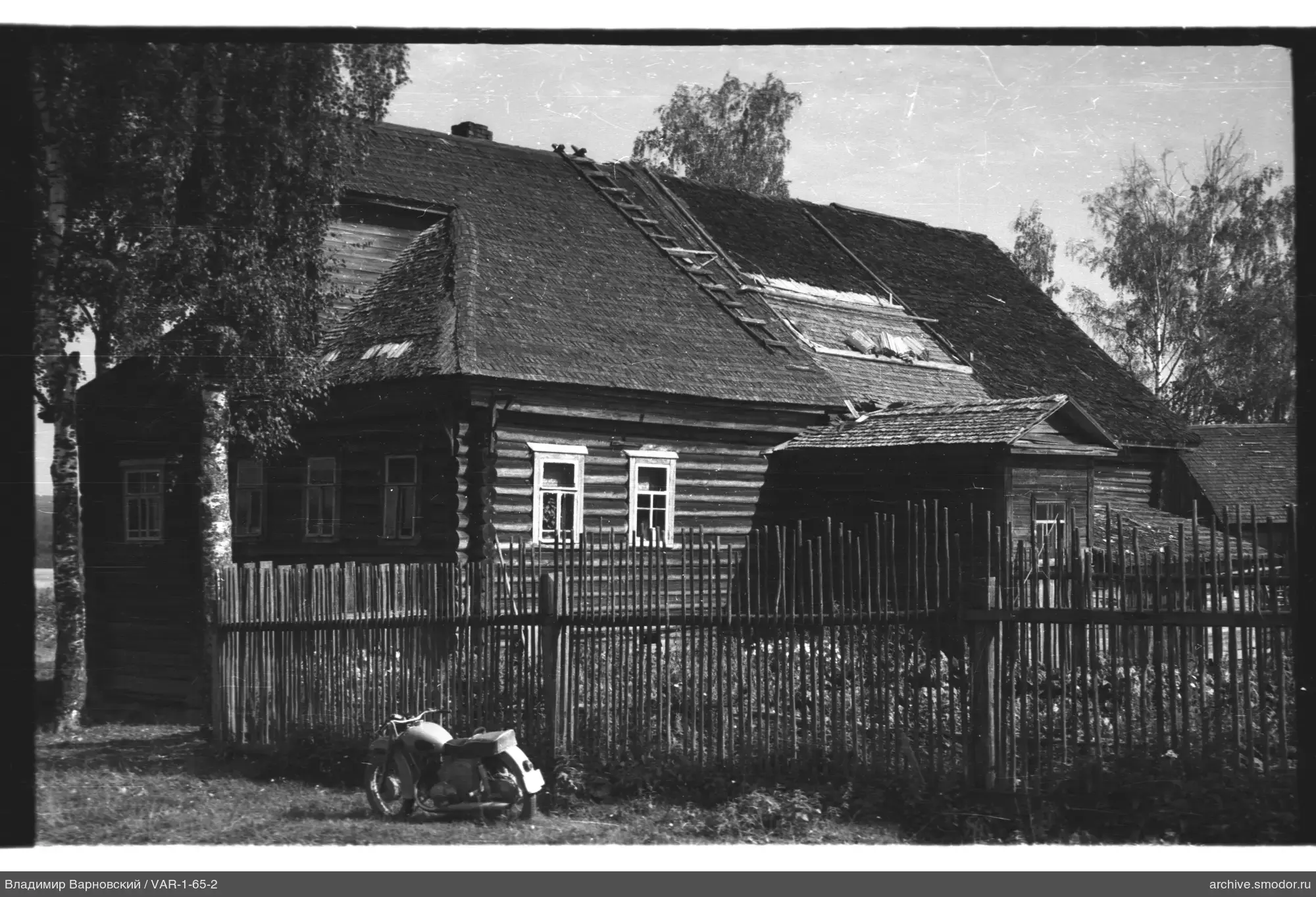 Holzhaus mit Motorrad und Birken