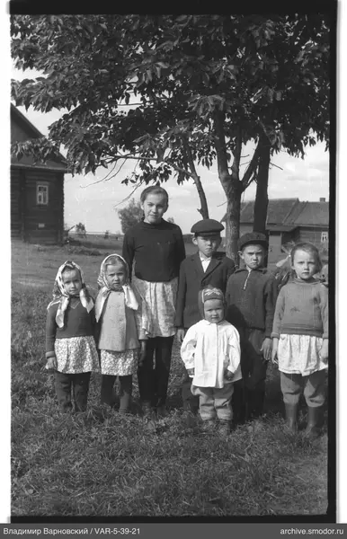 Gruppe von Kindern auf Gras unter einem Baum