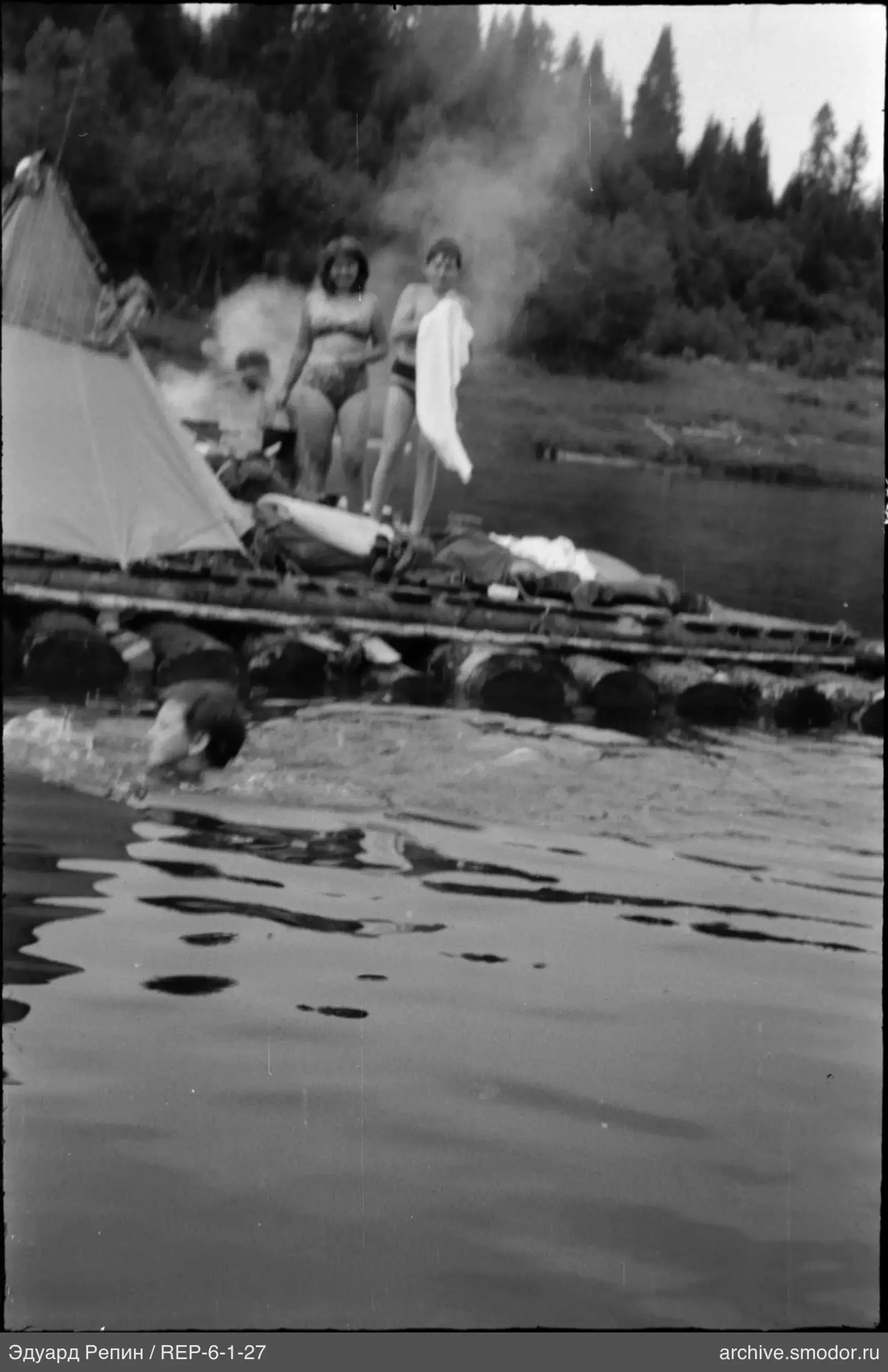 Человек плавает в воде у берега
