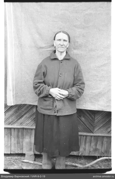Frau in dunkler Kleidung vor Wand