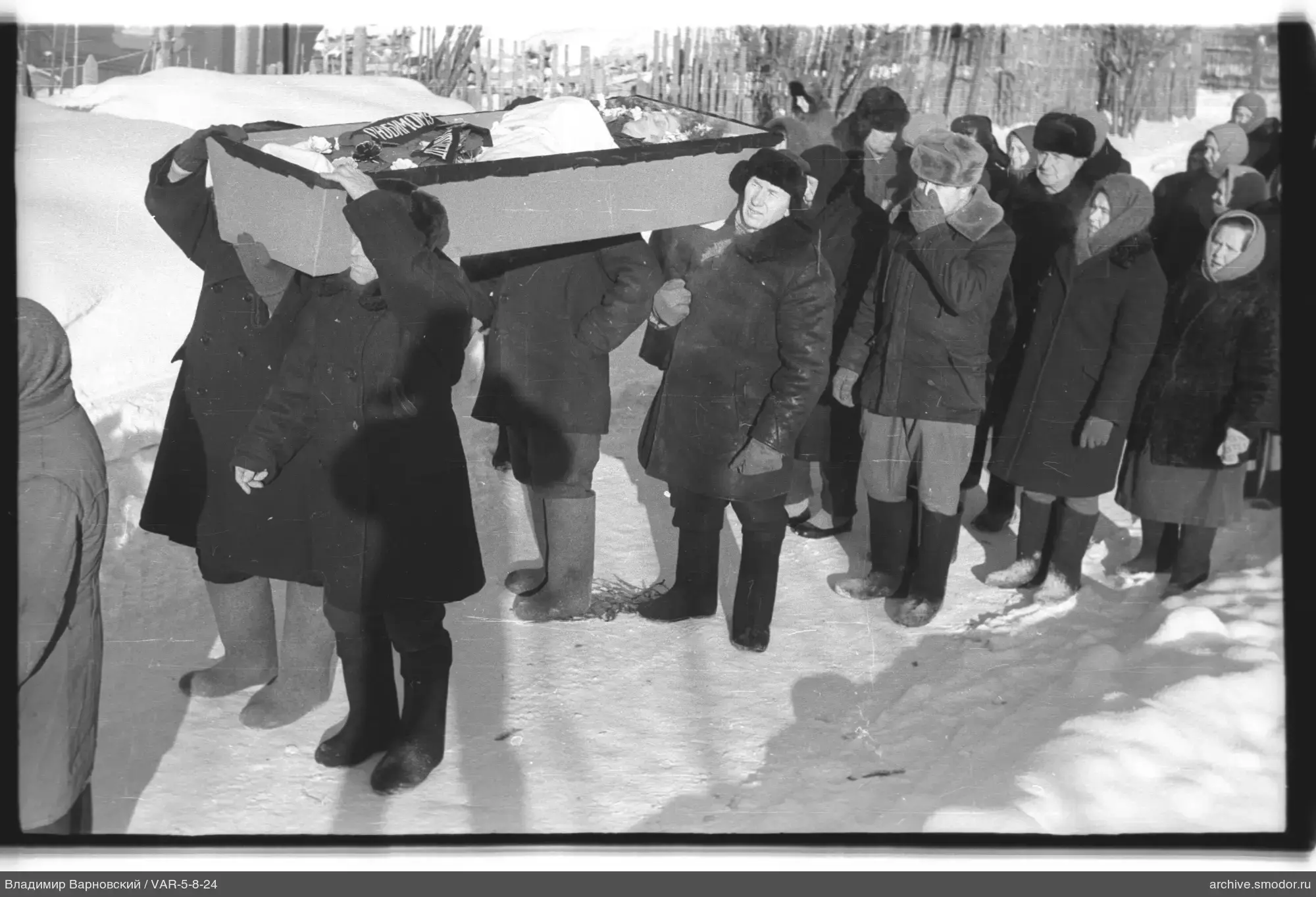 Мужчины несут гроб на похоронах