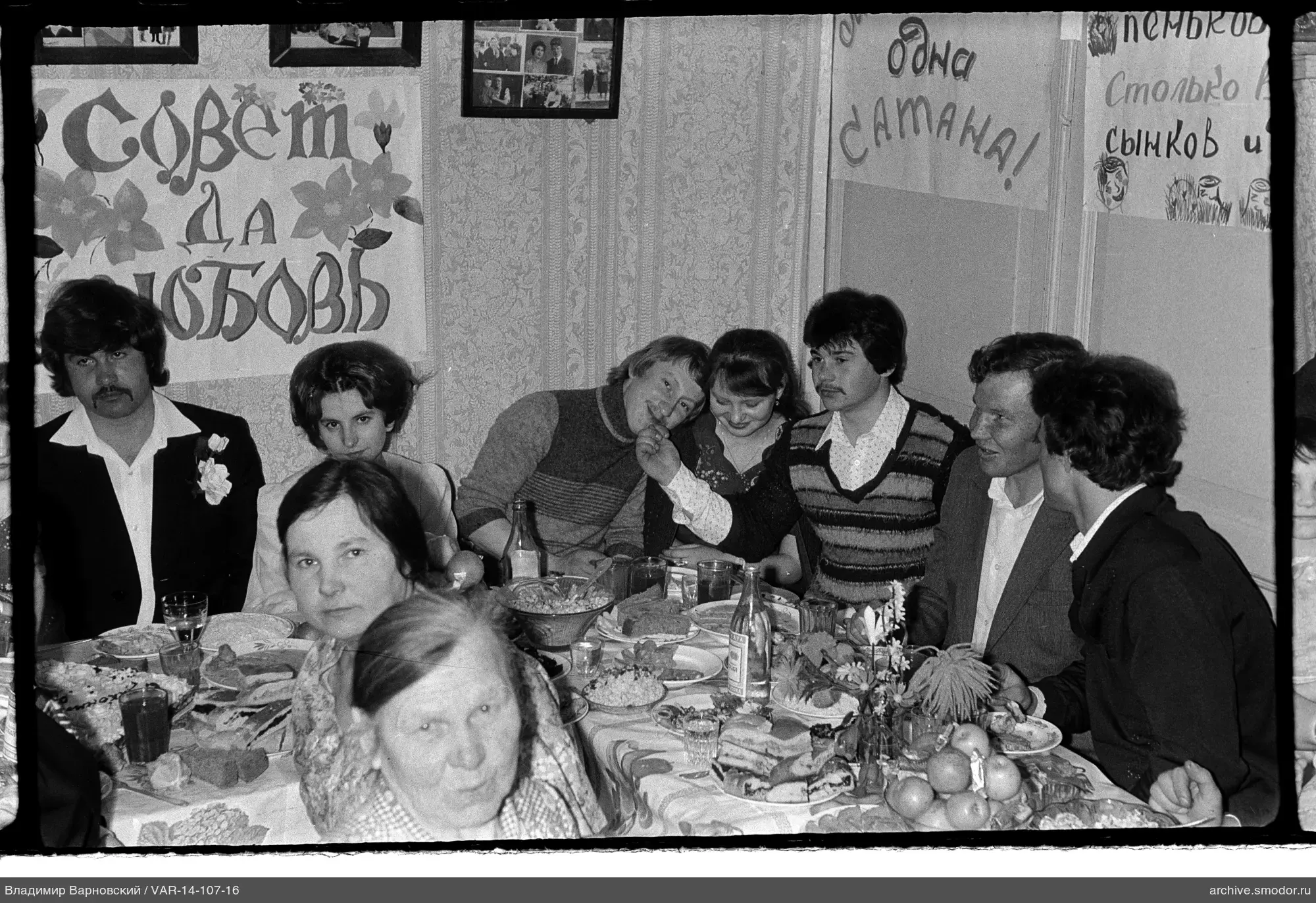 Gruppe mit Essen und Postern am Tisch