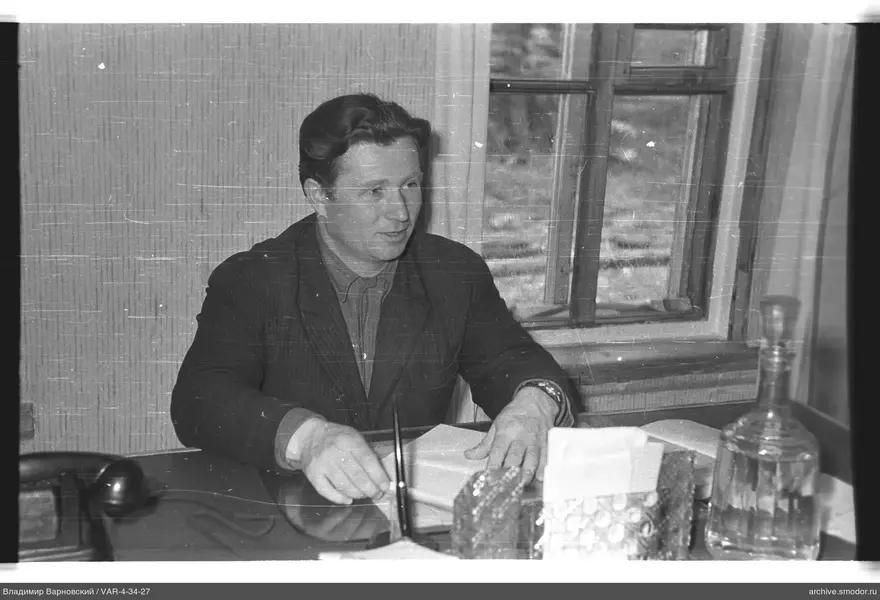 Mann am Tisch mit Papieren und Telefon