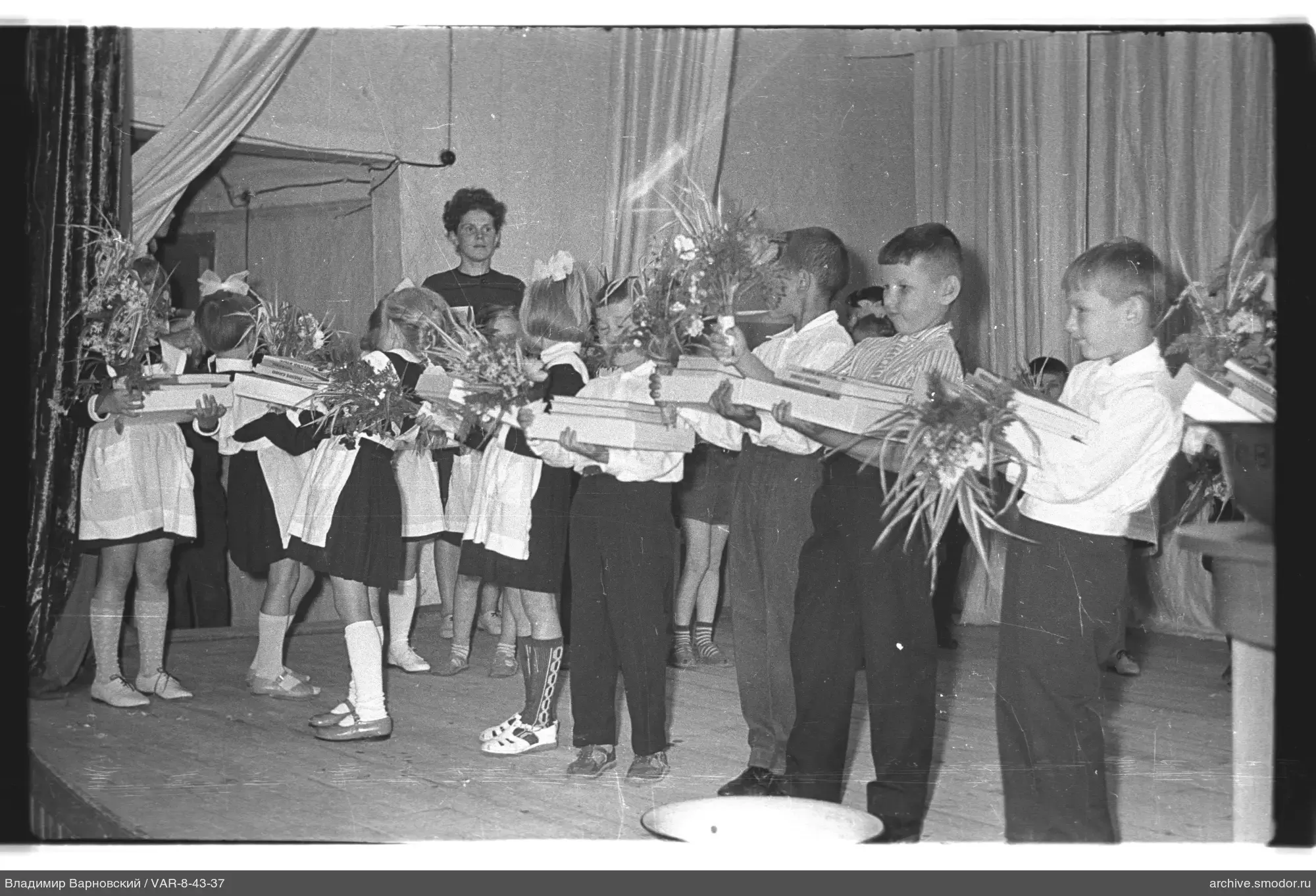 Gruppe von Kindern auf der Bühne mit Blumen