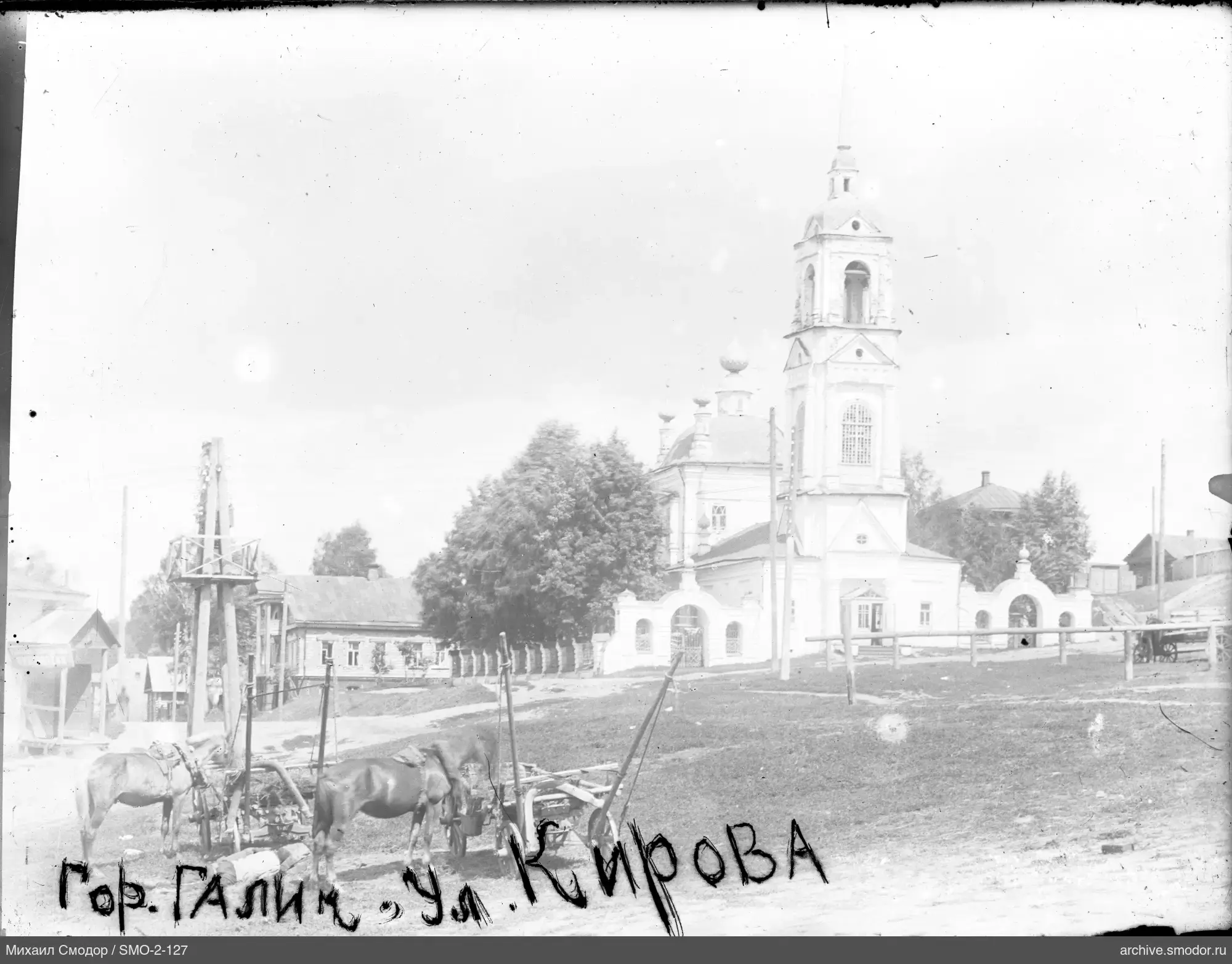 Pferde auf der Straße mit Kirche und Häusern