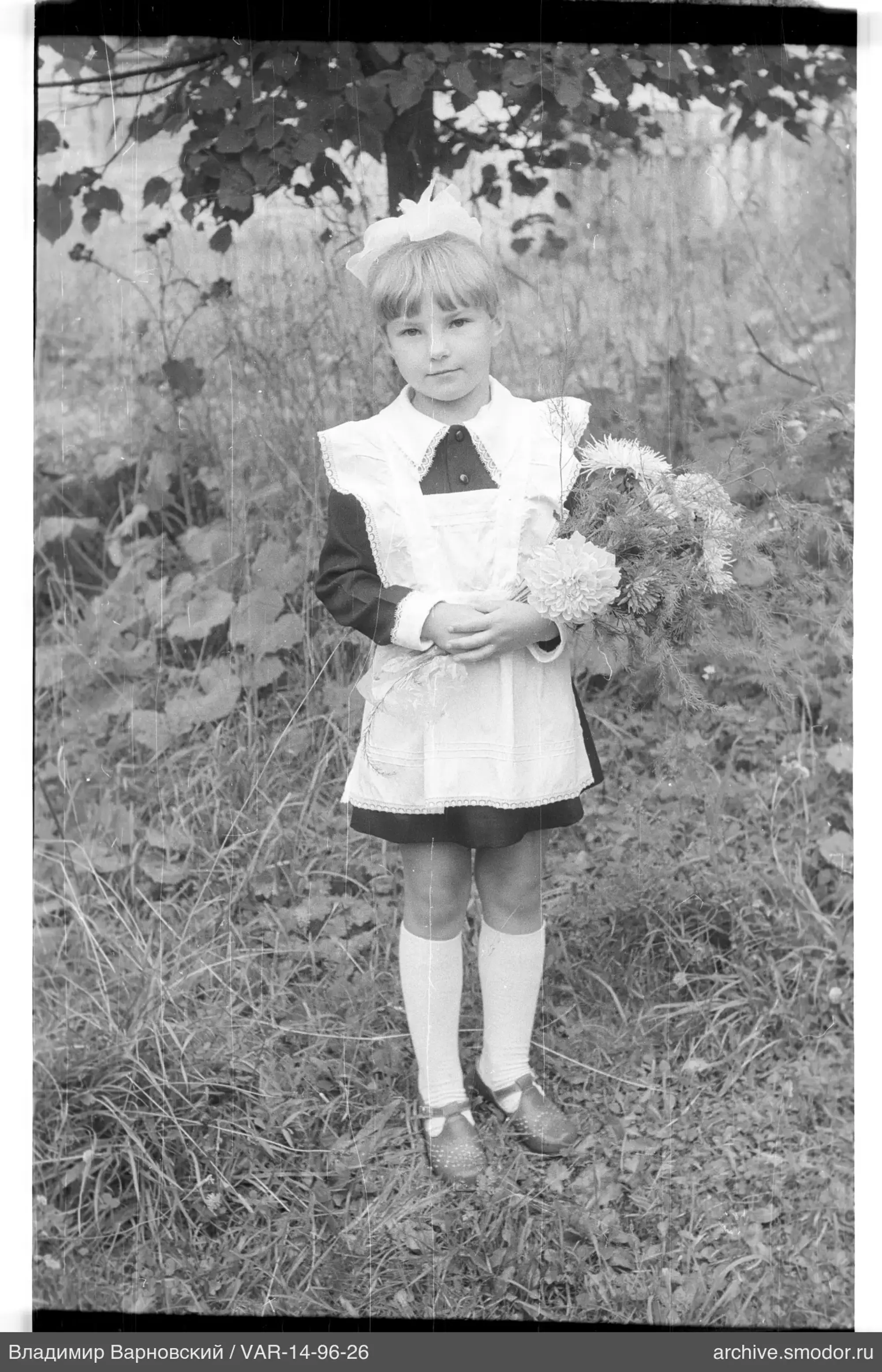 Girl with bouquet under a tree