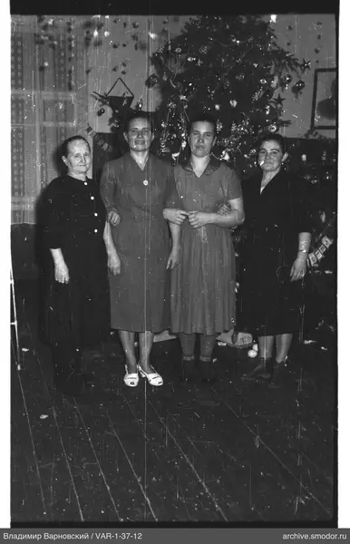 Gruppenporträt von Frauen vor Weihnachtsbaum
