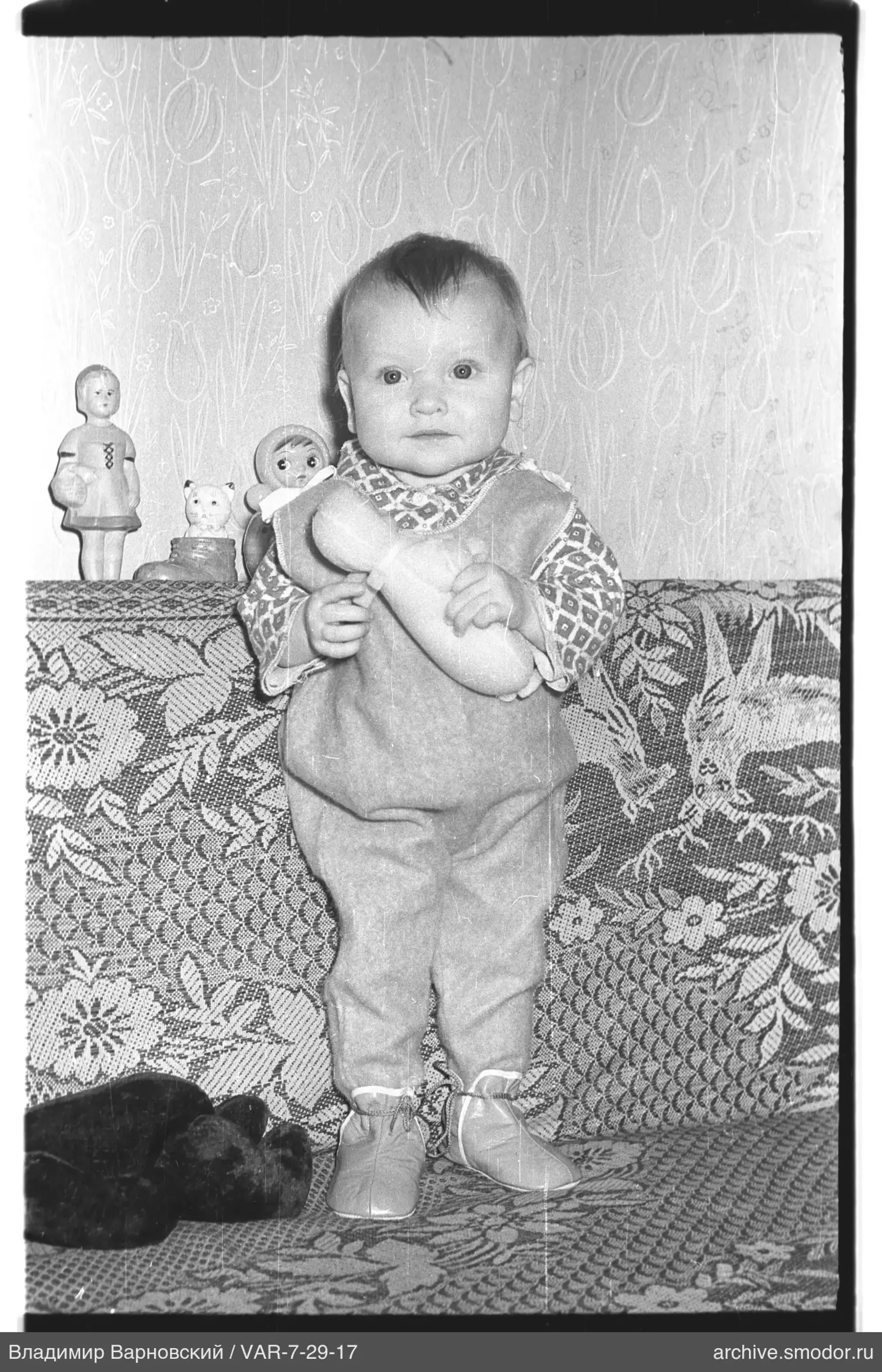 Kind mit Puppe auf Sofa