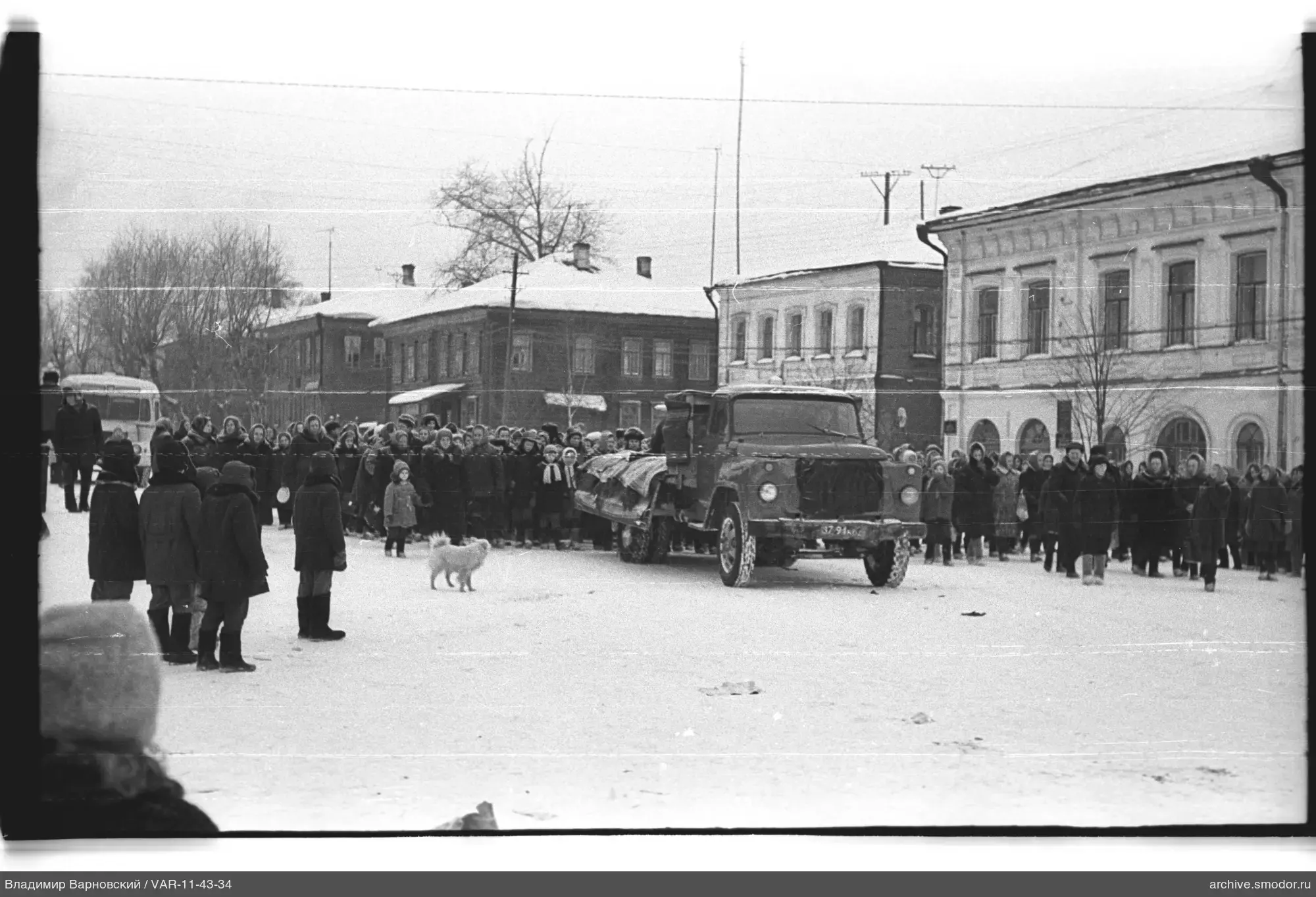 Gruppe von Menschen und Lastwagen auf verschneiter Straße