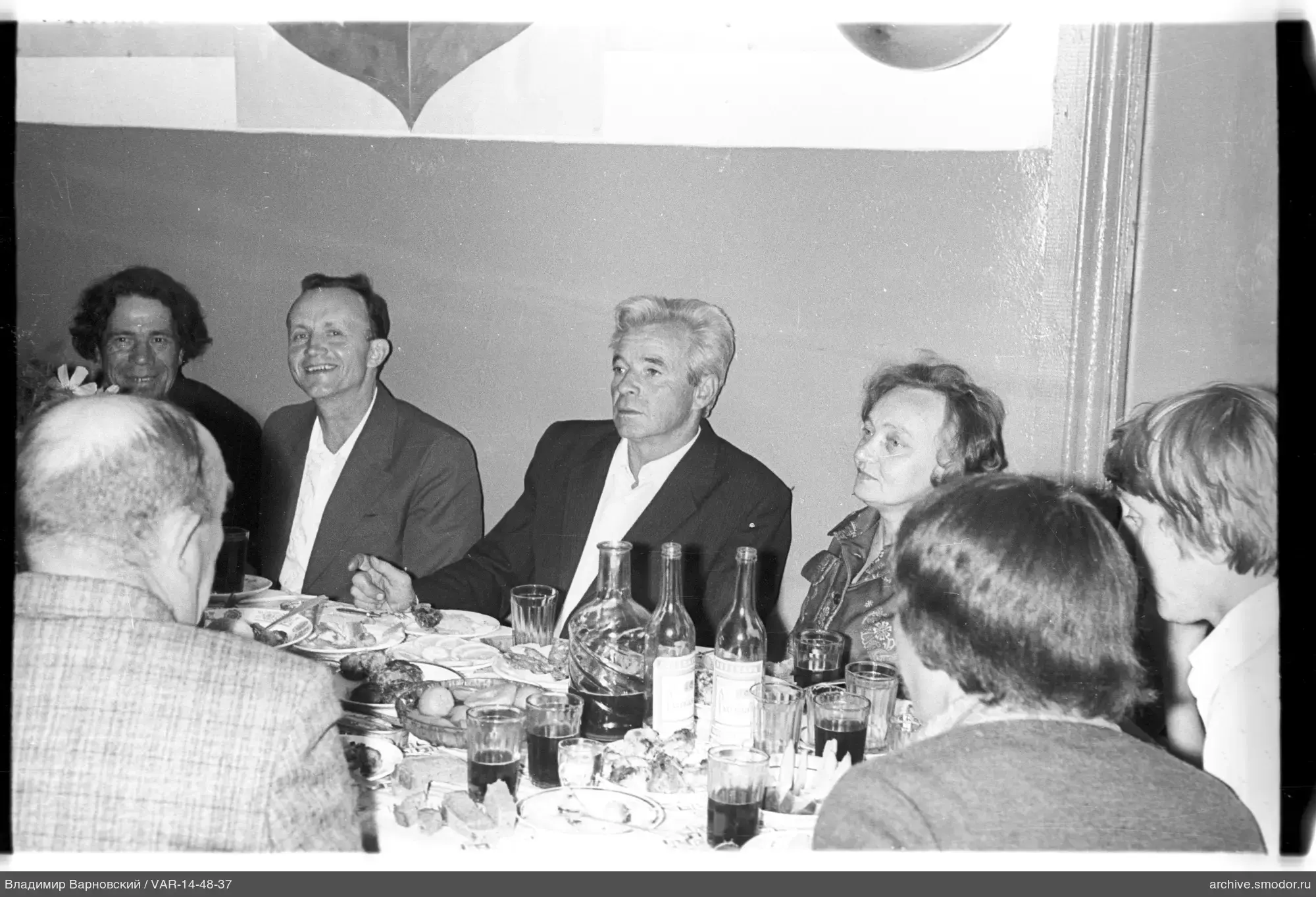 Group of people at a table with food and drinks