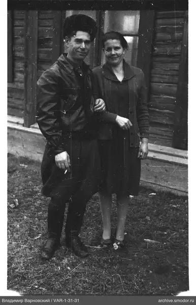 Mann und Frau neben einem Holzhaus
