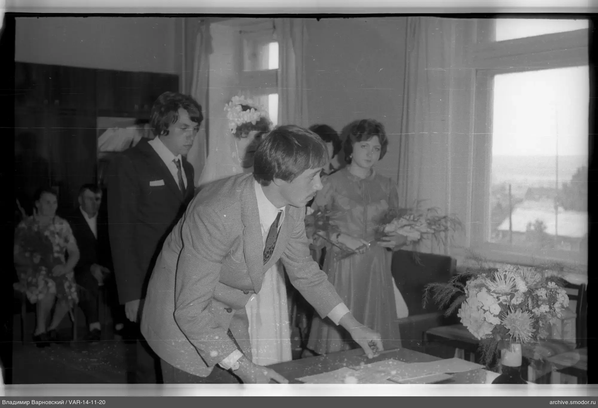 Mann mit Papieren und Hochzeitspaar