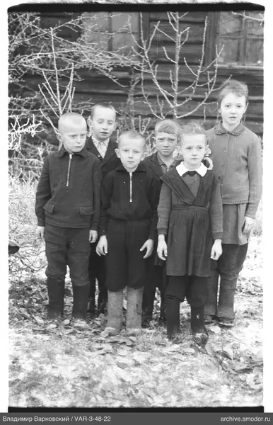 Gruppenporträt von Kindern vor Haus und Laub