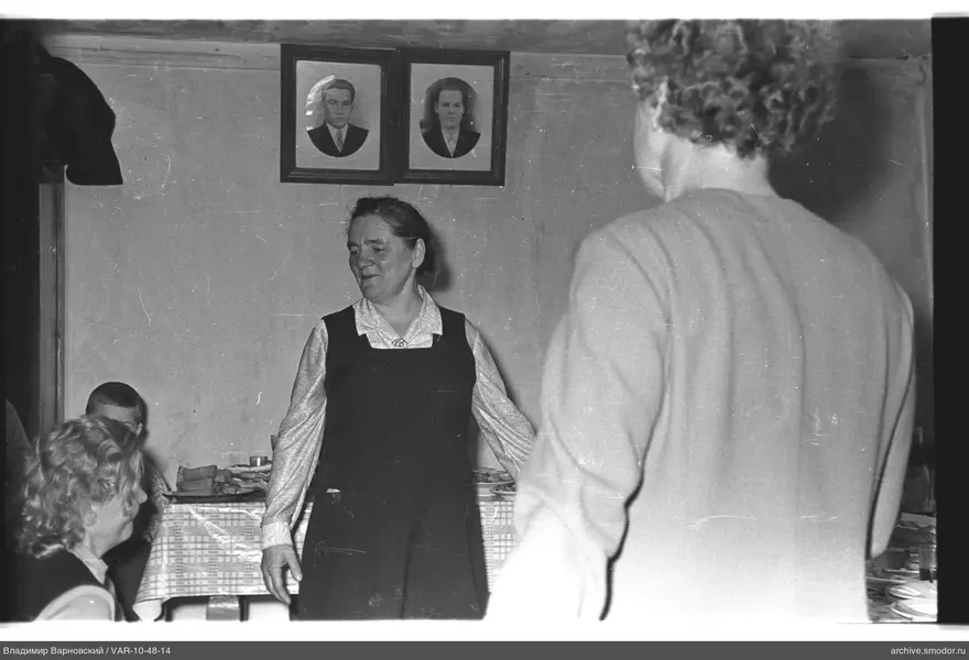 Group of people in a room with portraits and table
