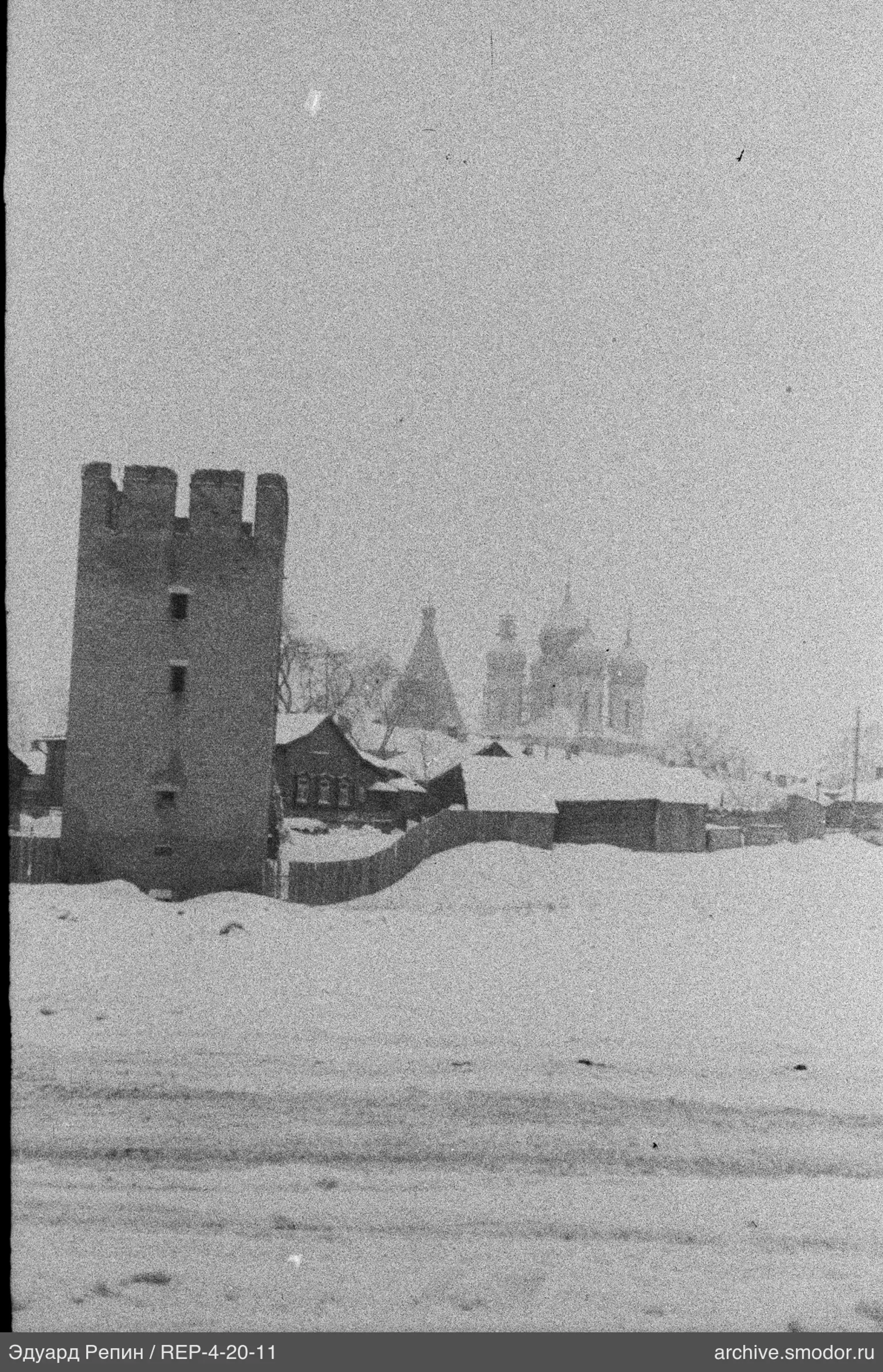 Высокая каменная башня и церковные купола