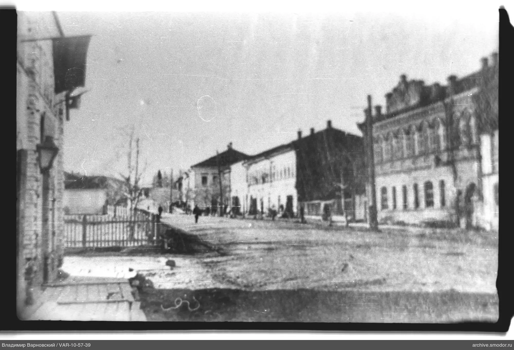Street with two-story buildings and leafless trees