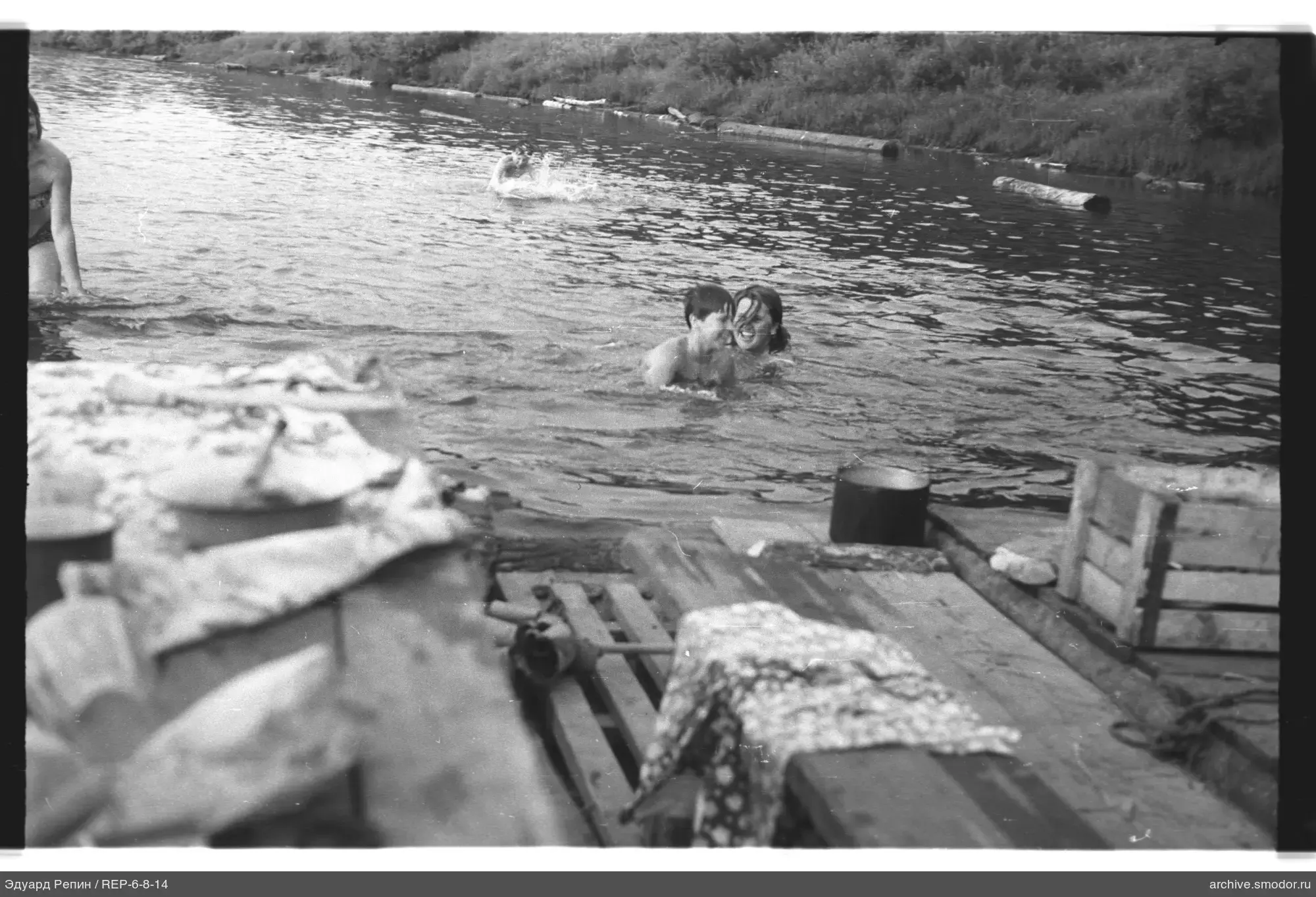 Children in the river with a raft