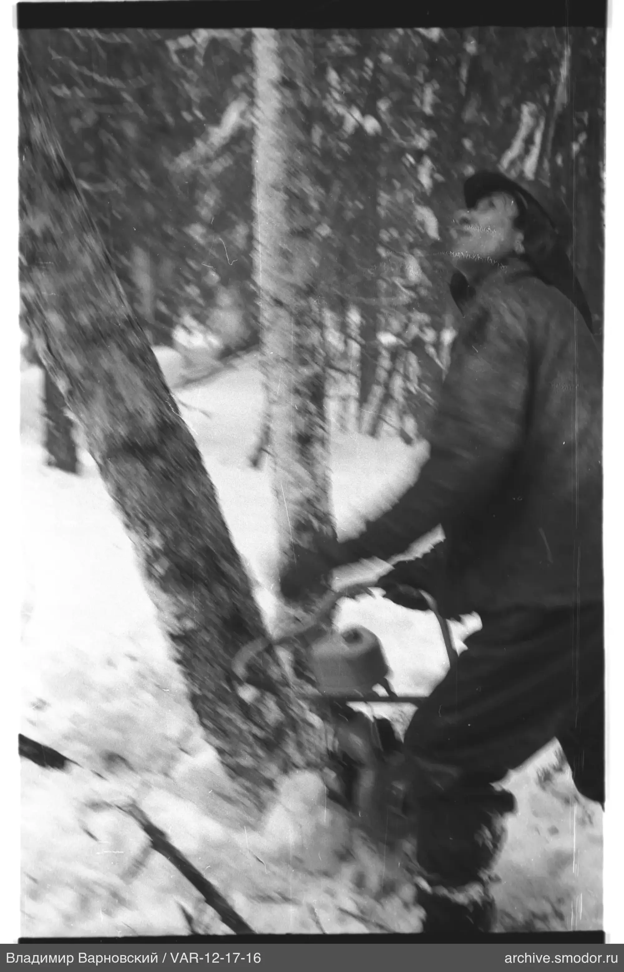 Mann mit Kettensäge im verschneiten Wald