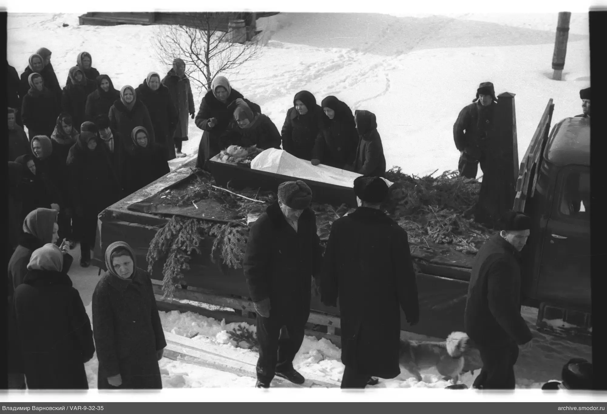 Группа людей у грузовой машины с гробом